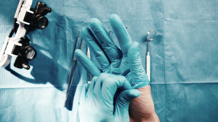 Dentist is wearing the blue gloves before the operation | Shutterstock HD Video #1099465845