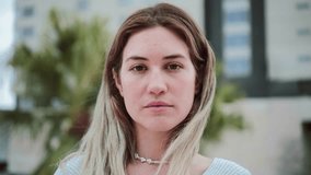 Close up portrait of blonde caucasian young woman looking serious at camera. Pretty teenage girl staring front with sad attitude. High quality 4k footage - Powered by Shutterstock - Get 15% off with code: PIKWIZARD15