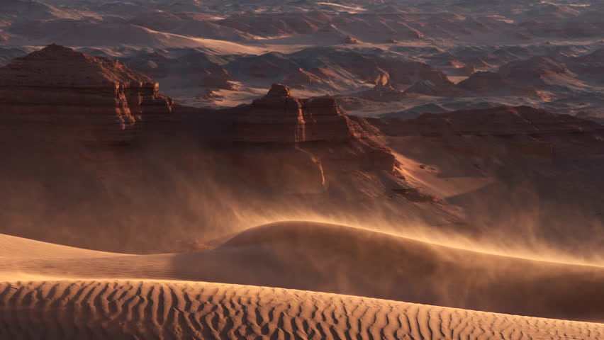 Sand blowing over dunes in wind, red cliffs on background, Gobi desert. Mongolia | Shutterstock HD Video #1099470611