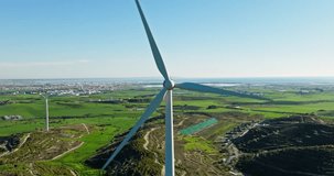 Aerial view of a windmill spinning in a mountain landscape. Production of ecological green electricity by windmill blades. High quality 4k footage