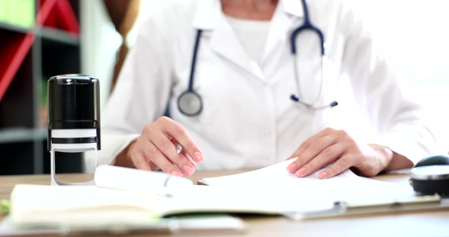 Doctor putting stamp on document in clinic closeup 4k movie slow motion 