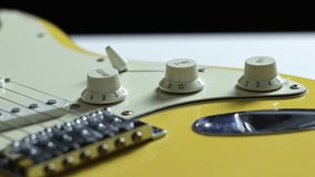 Observe a close-up of a young woman rocker's hands as she plays an electric guitar, adjusting the volume knob - Powered by Shutterstock - Get 15% off with code: PIKWIZARD15