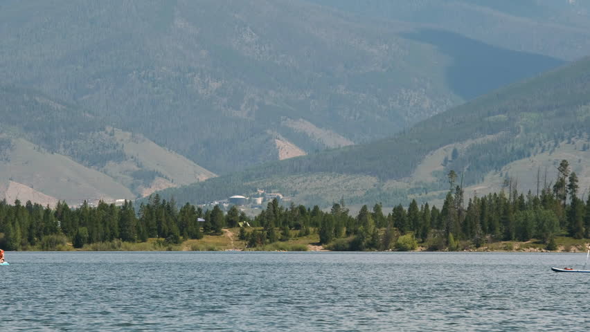 Two people riding paddleboards across Lake Dillon in Colorado