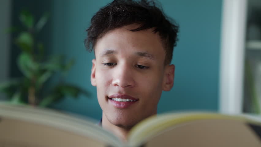 Hipster guy reading a book in a stylish interior. Close up
Student preparing for the exam  and searching for information.
Young man spends time at home looking at a book with interest | Shutterstock HD Video #1099482493