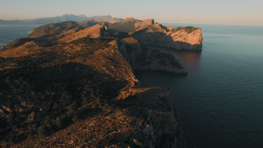 Rocky mountains washed by Mediterranean Sea during sunrise, drone point of view. Formentor, Spanish Island of Majorca or Mallorca, the largest island in the Balearic Islands, Spain | Shutterstock HD Video #1099485121