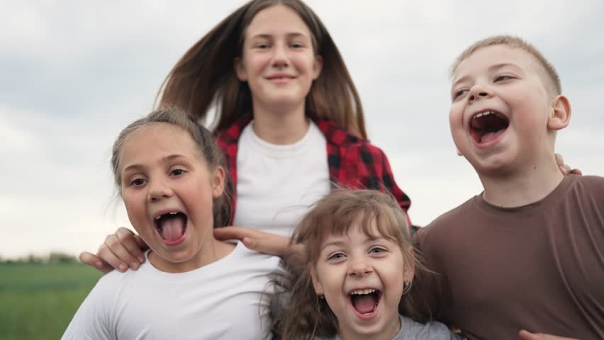 Children play in park.Happy family concept. Faces of kid in camera. Children jump hugging. Happy kid laughing in park. Jumping and joy of children. Happy family at sunset. Happy faces close up in park | Shutterstock HD Video #1099487987