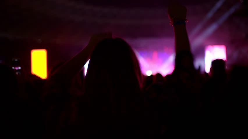 Silhouette of a fan of dancing and having fun at a concert of her favorite band | Shutterstock HD Video #1099490029