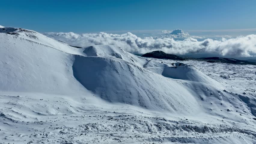 Aerial shot with drone of Etna in winter. Snow-covered craters, Etna in activity, Valle del Bove and summit craters. Snowy woods. South-East, North-East, Voragine, Bocca Nuova. 