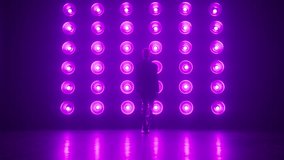 Alone female professional dancer performing a Modern hip hop or jazz funk dance in front colorful pink purple light wall during a Video Production in Studio Environment. Dance footage background RED