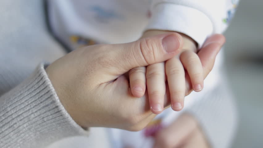 portrait of crying baby sleepy child in mom arms rubbing eyes making air and graces whims.mother caresses little cute toddler infant kid hand.nervous baby shaking milk teeth make grimaces