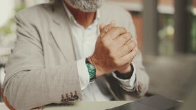 Close-up of the hands of mature businessman having video conference, video call on laptop pc computer sit at cafe outdoor. Middle aged manager massage hands, gesture - Powered by Shutterstock - Get 15% off with code: PIKWIZARD15