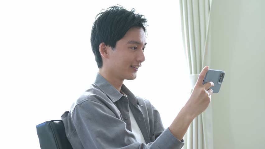 Young Japanese looking at mobile phone | Shutterstock HD Video #1099503755