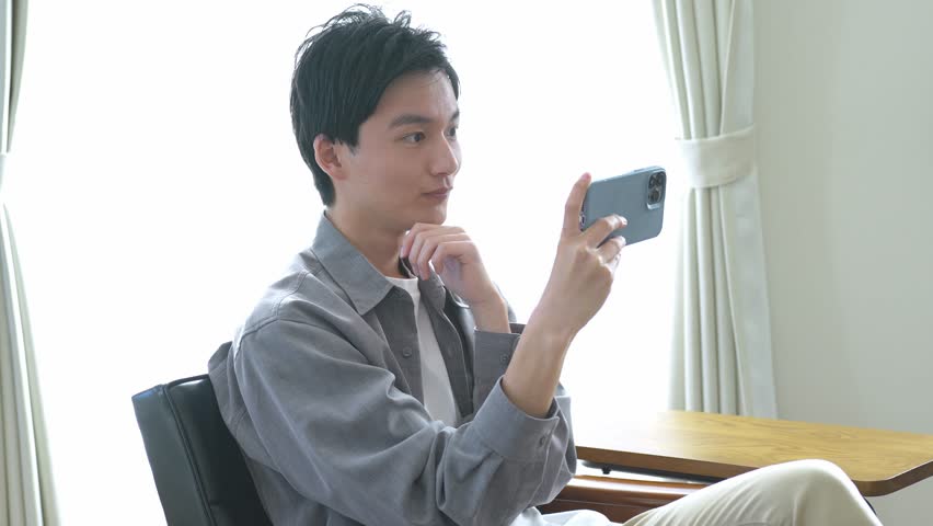 Young Japanese looking at mobile phone | Shutterstock HD Video #1099503757