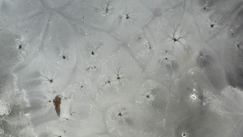 Melting spring ice with  fishing holes , aerial view