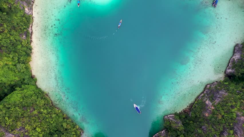 Aerial drone photo of iconic tropical turquoise water Pileh Lagoon surrounded by limestone cliffs, Phi phi islands, Thailand | Shutterstock HD Video #1099510993