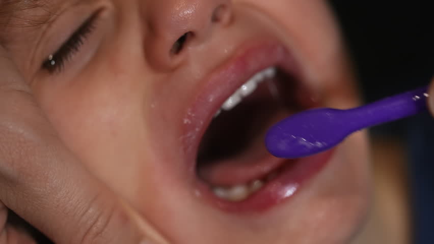 Crying toddler with open mouth. Parent brushing child teeth. One small boy dental hygiene | Shutterstock HD Video #1099511485