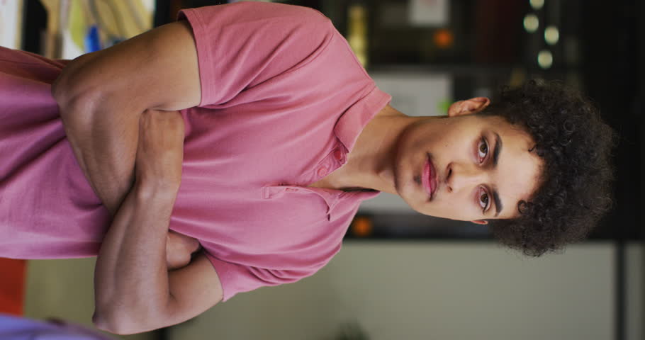 Vertical video of portrait of happy biracial businessman at office. Work at a modern office.