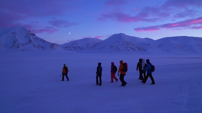 Group of travelersr goes by a strong storm in Svalbard near Longyearbyen. Arctic landscape of a snowy mountain near Longyearbyen Spitsbergen. Northern landscape Norway, Svalbard. Full HD ProRes video