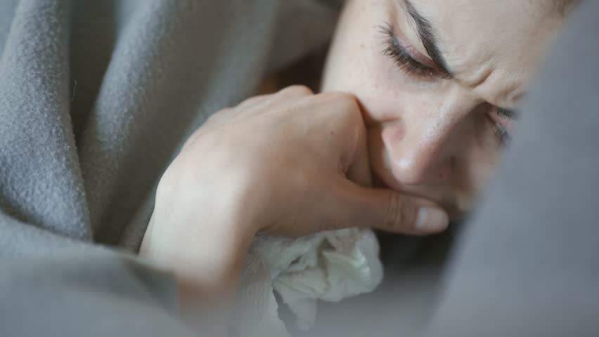 Young woman lies alone on bed at home, cold and sick. illness, cold, virus, doctor's call at home, consultation with a doctor by phone | Shutterstock HD Video #1099514057