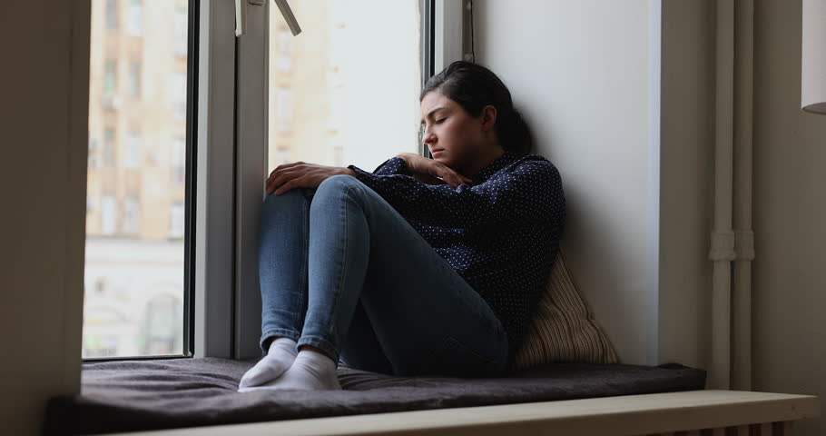 Depressed passive young Indian woman sitting on windowsill with closed eyes, waking up, looking out of window, feeling tired, exhausted, sad frustrated, thinking over problems, bad news, loss Royalty-Free Stock Footage #1099514561