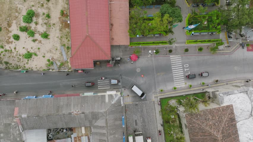 Top down aerial footage of an intersection in Panajachel, Guatemala with cars going and stopping and people walking. | Shutterstock HD Video #1099515913