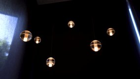 Shot of beautiful hanging orb lights turning on and off (4K) - Powered by Shutterstock - Get 15% off with code: PIKWIZARD15
