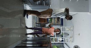 Vertical video of african american father and daughter dancing. Enjoying quality family time together at home.