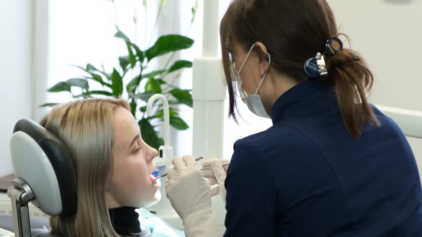 Dentist and client during dental treatment in the dental office. Oral care. | Shutterstock HD Video #1099518871