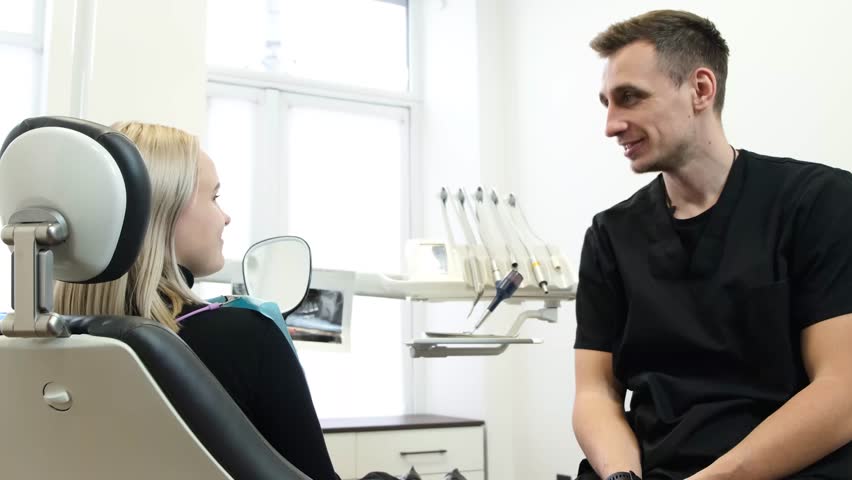 Positive and smiling dentist and patient in dental clinic. Healthy teeth. Healed teeth | Shutterstock HD Video #1099518971