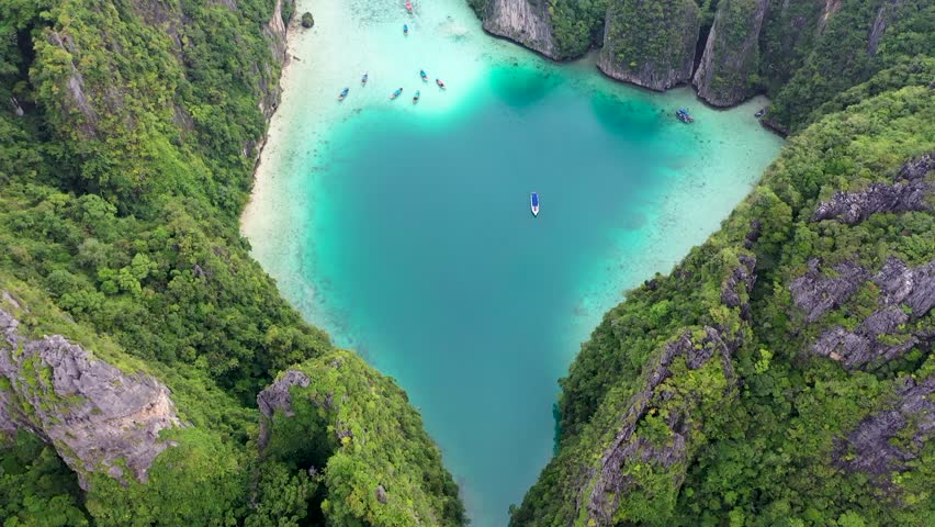 Aerial drone photo of iconic tropical turquoise water Pileh Lagoon surrounded by limestone cliffs, Phi phi islands, Thailand | Shutterstock HD Video #1099519065