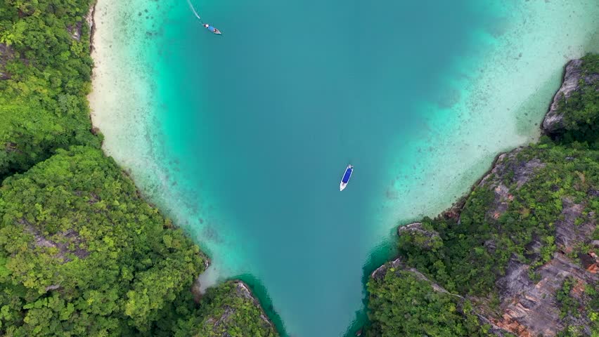 Aerial drone photo of iconic tropical turquoise water Pileh Lagoon surrounded by limestone cliffs, Phi phi islands, Thailand | Shutterstock HD Video #1099519073