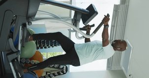 Vertical video of happy african american men is exercising at the gym. Senior lifestyle, retirement lifestyle, active leisure time.