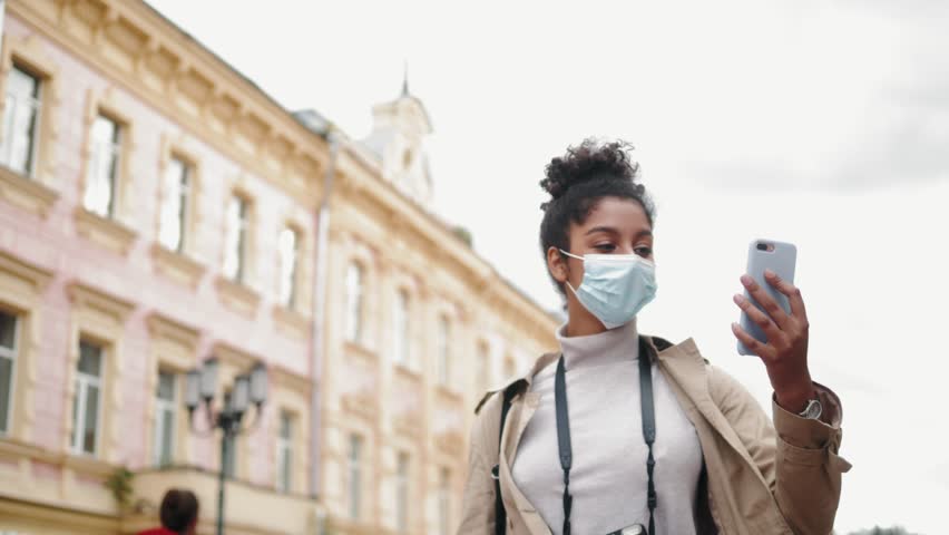 Happy African American young woman in medical mask with Afro hair holding smartphone making video call conference, social media blog, video chat with friends, black student girl making selfie | Shutterstock HD Video #1099521983