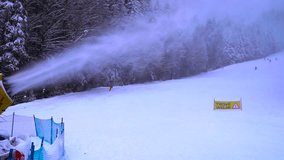 snow cannons in operation on one side. skiers on the slopes. winter sports. 4k video.