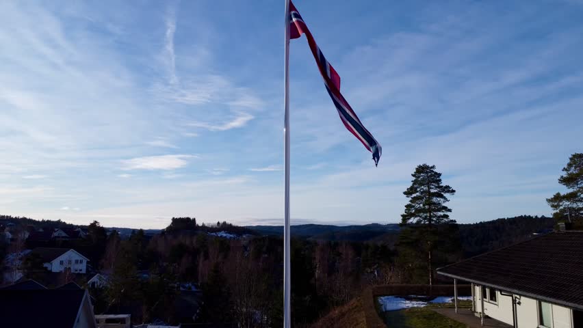 Norwegian flag waving in the wind with a blue sky background | Shutterstock HD Video #1099523261