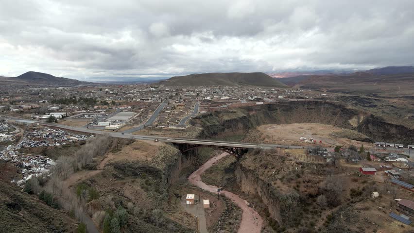 Bridge over the Virgin River in La Verkin, Utah with a panning aerial reveal of the city