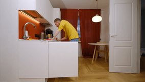Middle-aged man watches educational video and fixes water pipe in kitchen