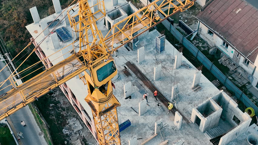 Aerial View A Construction Crane Is Working On A Construction Site. Top View Of Builders Building A House | Shutterstock HD Video #1099526619