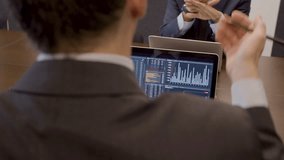 Data analysts sitting in meeting room and working together. Medium shot of unrecognizable professional traders looking at computer screen with analytics feed and talking. Occupation, business concept - Powered by Shutterstock - Get 15% off with code: PIKWIZARD15