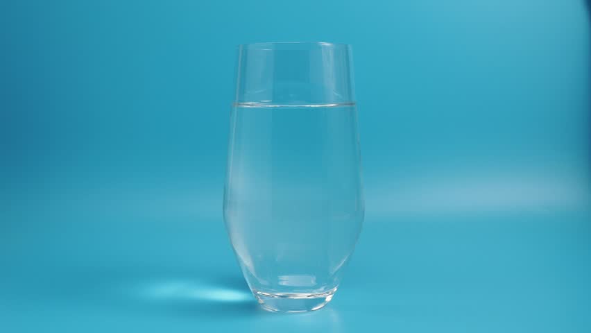 Effervescent tablet in a glass of water close-up on a blue background. Health concept. | Shutterstock HD Video #1099530143