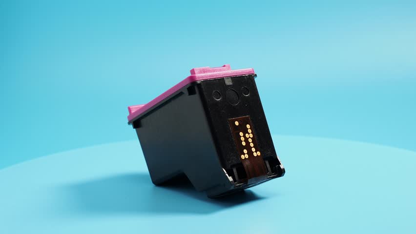 Rotating cartridge with printer ink on a blue background. Close-up.
