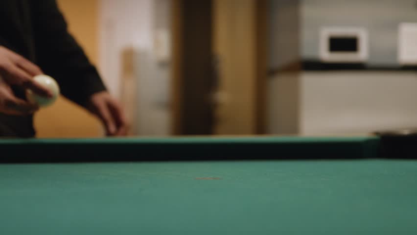 Slow-mo, placing a white cue ball into a clean pool table and hitting the white cue ball with a pool cue stick, medium shot from table level | Shutterstock HD Video #1099530165