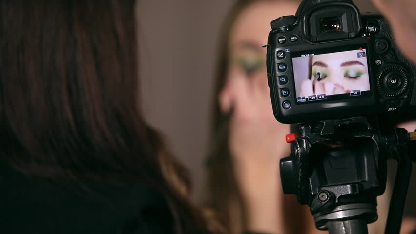 Professional videographer filming a video of a professional make-up artist, back view | Shutterstock HD Video #1099530493