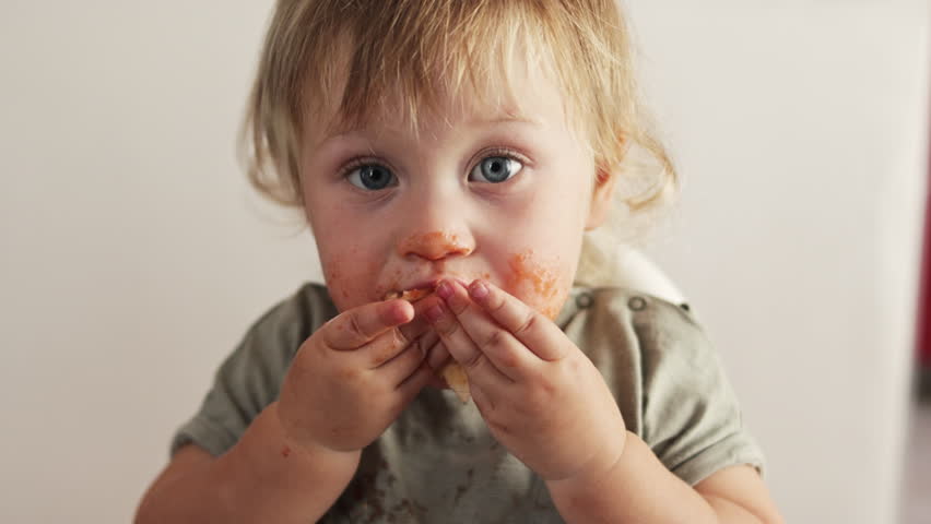 Closeup view of funny dirty small boy after eating pizza. Tomato lips and teeth. Child licking fingers. | Shutterstock HD Video #1099533347