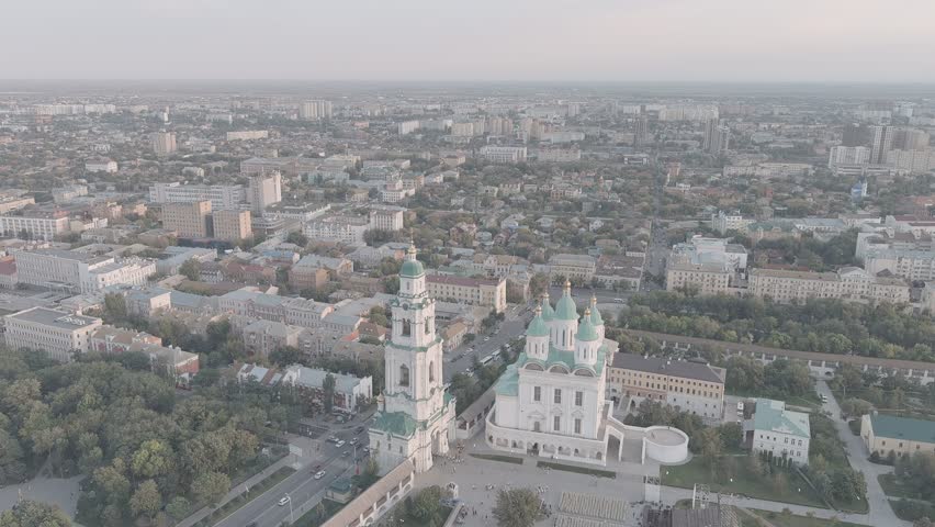 Astrakhan, Russia. The Cathedral of the Assumption of the Blessed Virgin and its adjoining bell tower dominate the Astrakhan Kremlin complex, captured in a sweeping aerial view during sunset. The church