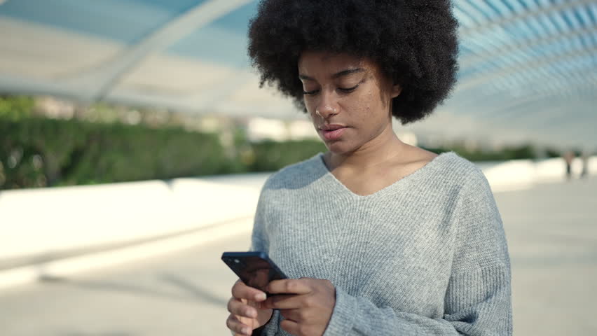 African american woman smiling confident using smartphone at park | Shutterstock HD Video #1099539513