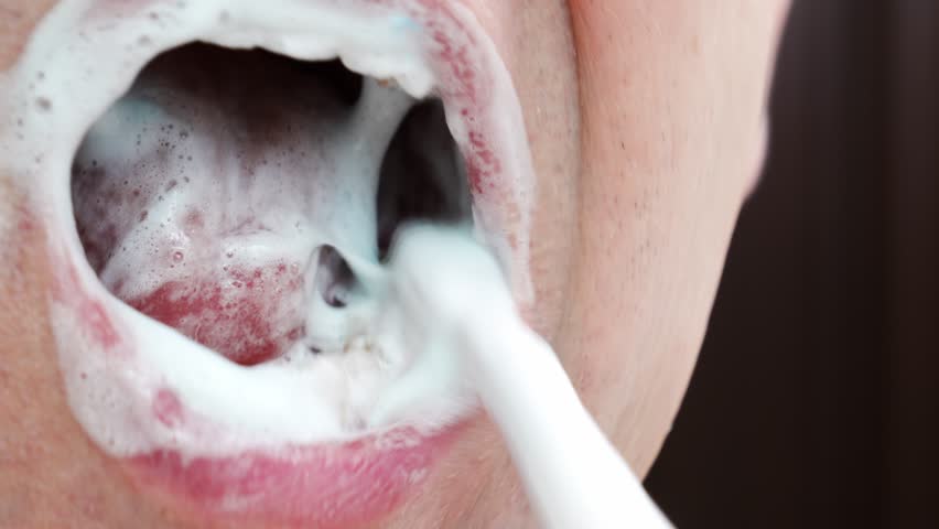 A man's mouth close-up. a man brush your teeth with toothbrush and toothpaste. concept of hygiene and health of teeth and oral cavity. daily care and brushing of teeth. | Shutterstock HD Video #1099541361