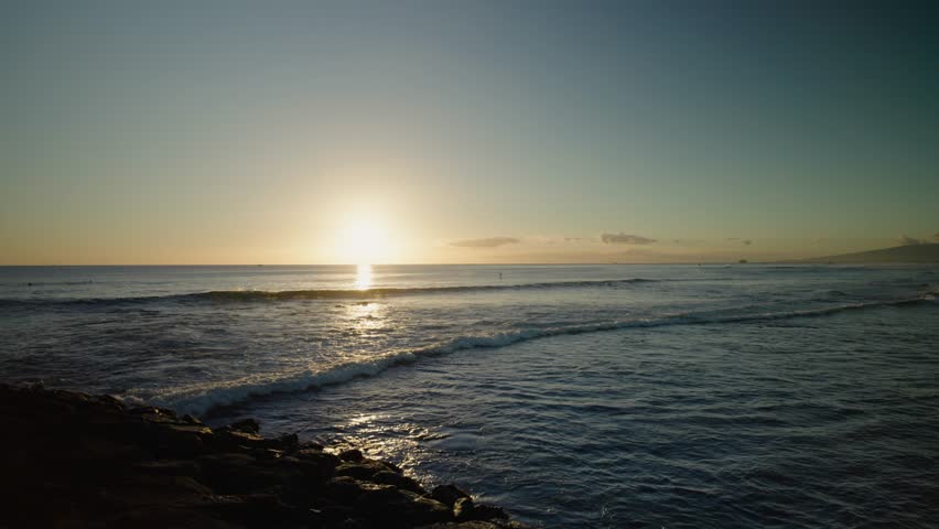 Majestic Timelapse of sunset over horizon of Honololu, Hawaii with cruise ship passing in front of the setting sun.