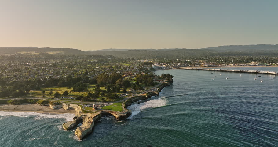 Santa Cruz California Aerial v3 cinematic drone fly around lighthouse point capturing state beach, neighborhood town and municipal wharf at sunset golden hour - Shot with Mavic 3 Cine - May 2022 Royalty-Free Stock Footage #1099543565