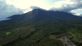 Fling in reverse over a forested volcano in Guatemala via drone. See blue skies, clouds, and nature in a peaceful, scenic, and relaxing video. A serene and tranquil visual experience